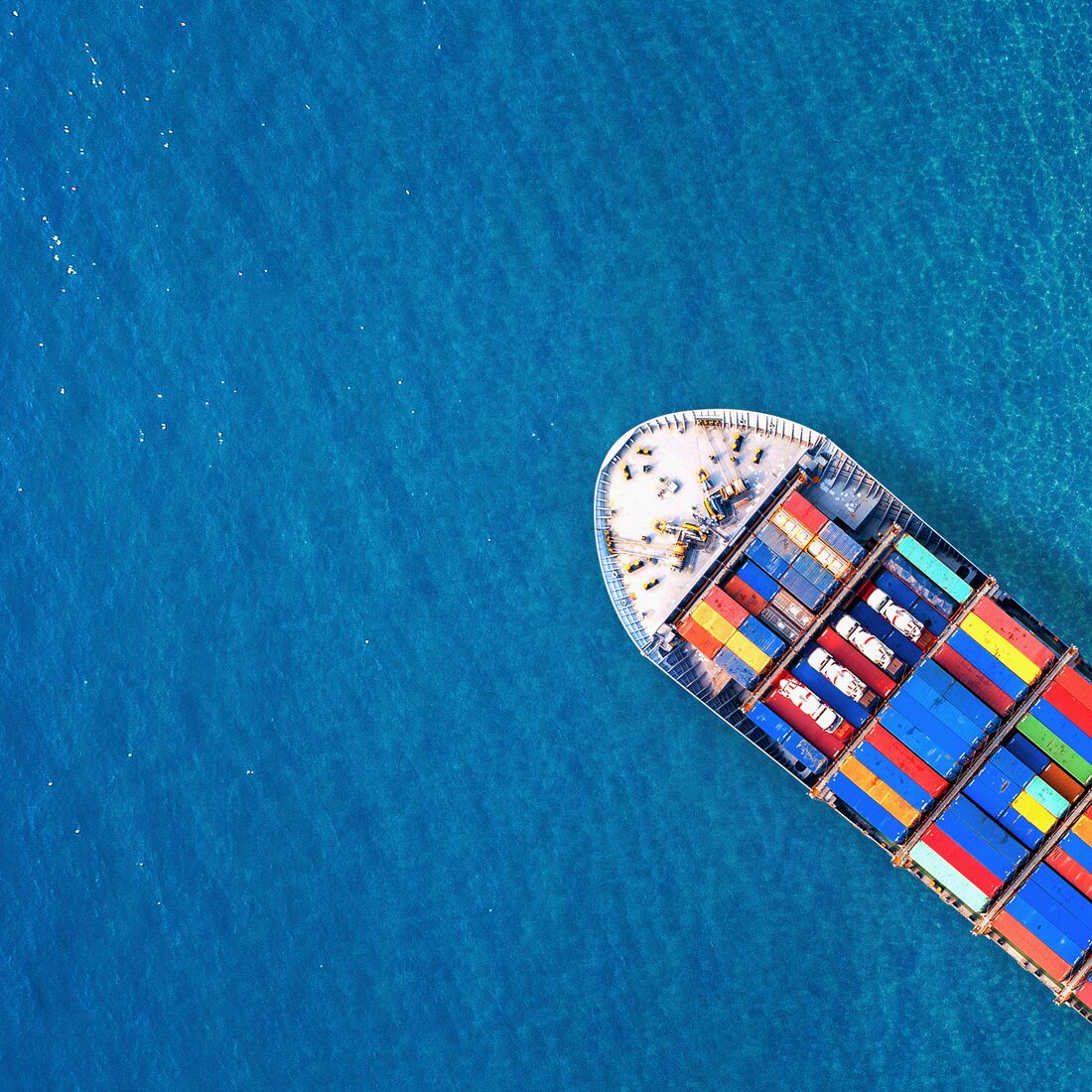 Aerial view of a fully loaded container ship crossing open ocean